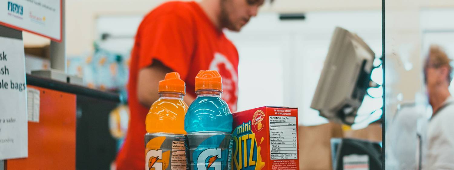 Shopper tapping Be Well card at a Rexall checkout to earn points in Canada