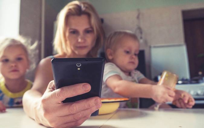 A Canadian family checking their phones for grocery coupon apps and cashback offers at home