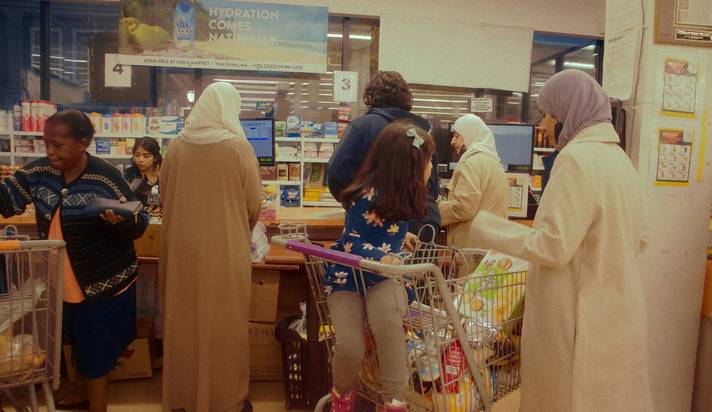 Canadian family in a grocery store holding up loyalty cards and smiling at the checkout
