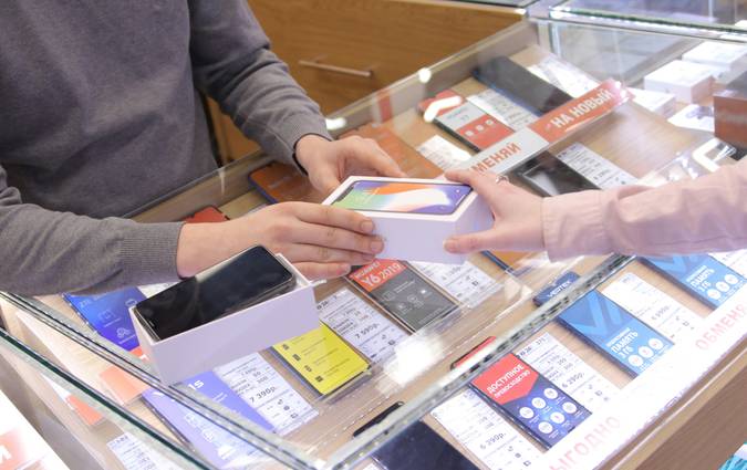 Canadian family saving money at the supermarket by comparing coupon and cashback apps on their smartphones