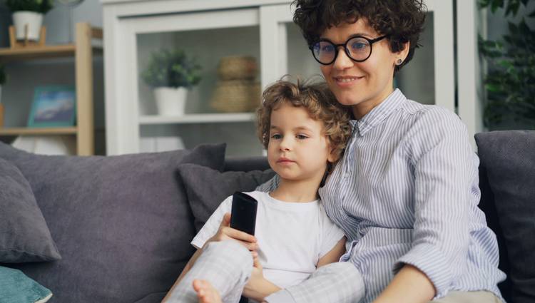 Canadian family using a smartphone for digital coupons while another prints grocery coupons at home
