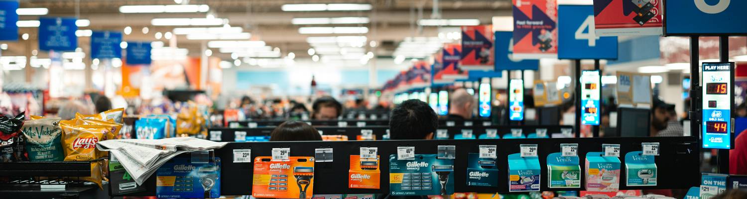 Canadian shoppers using coupons and comparing receipts in a grocery store aisle