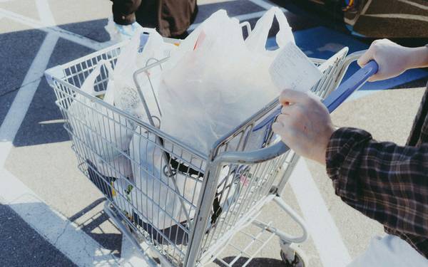 Canadian shopper redeeming grocery coupons at checkout, holding a savings receipt