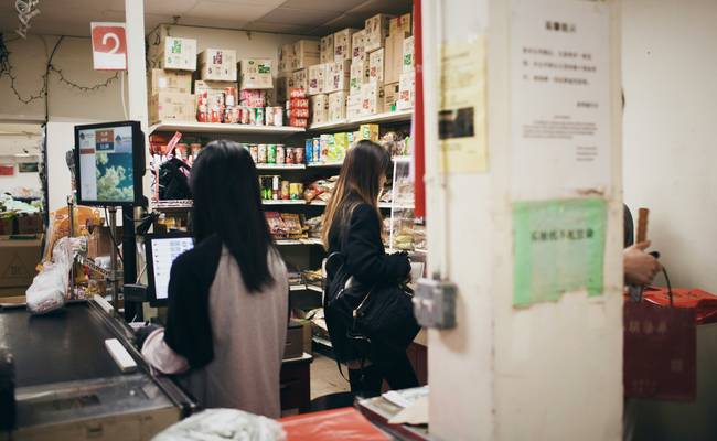 Canadian family using coupons at a grocery store checkout in Canada