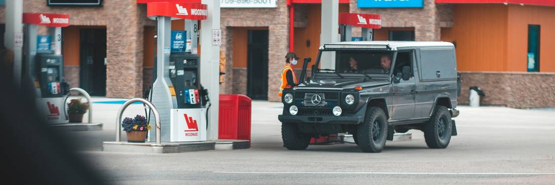 Driver paying at a Canadian gas pump while collecting loyalty points