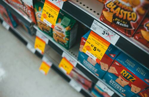 Close-up of Costco clearance price tags ending in .97 and asterisk, on a warehouse aisle shelf