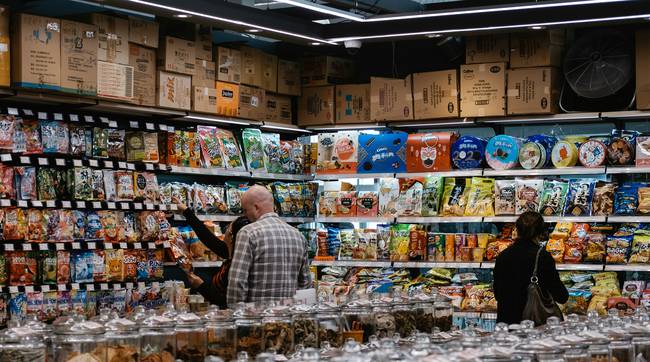 Shoppers using coupons and instant savings at a busy Costco warehouse in Canada