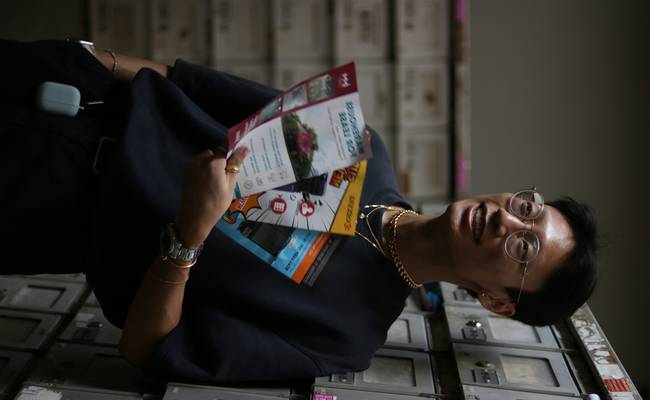 Canadian shopper holding a Costco receipt at the customer service desk, smiling while getting a price adjustment