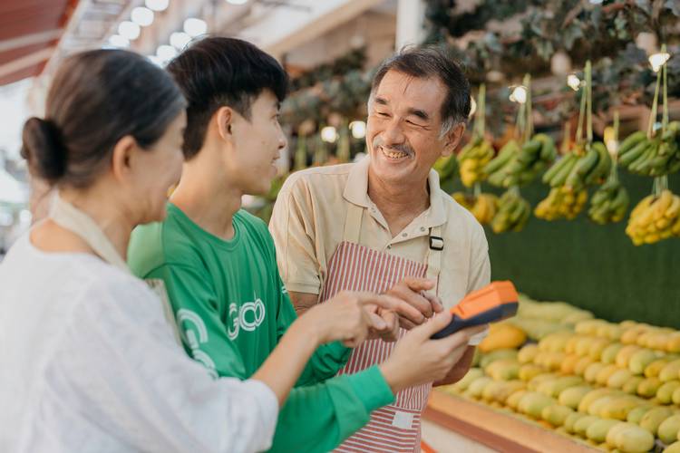 Costco member discussing a price adjustment with customer service, holding a flyer
