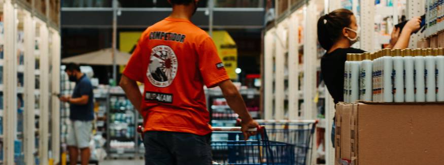 Canadian shoppers browsing Costco warehouse aisles with coupons and savings booklets in hand
