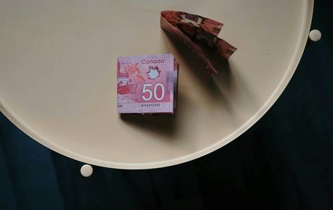 A Canadian shopper’s coupon binder open on a kitchen table, sorted neatly by store and expiry date