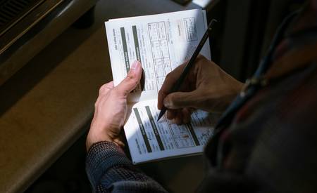 A person organizing coupons in a binder, tracking expiry dates for grocery savings