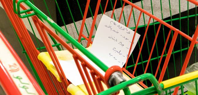 Shopping cart filled with groceries and coupons at Canadian supermarket