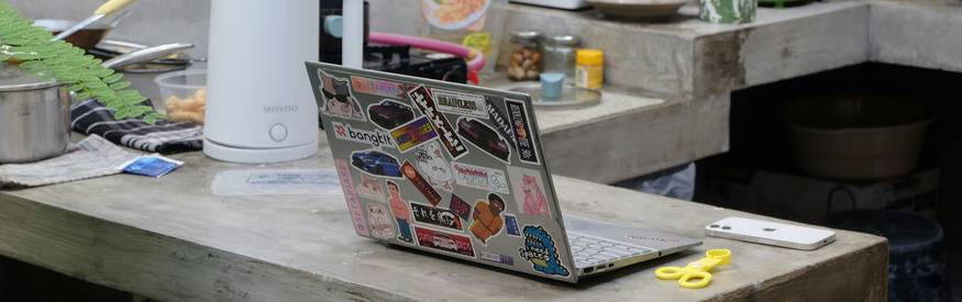 Person organizing paper and digital coupons at a kitchen table in Canada