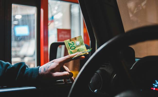 Canadian Tire shopper using Triangle Rewards app and CT Money card at checkout to earn rewards