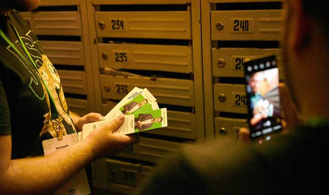 A Canadian shopper at a grocery store checkout scanning digital coupons on their phone for stacking savings
