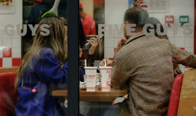 Canadian family redeeming digital coupons on a smartphone while grocery shopping