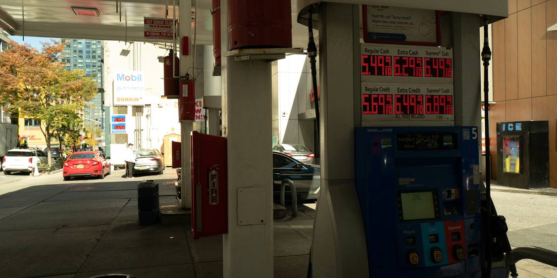 Canadian driver fueling car at gas station with credit card