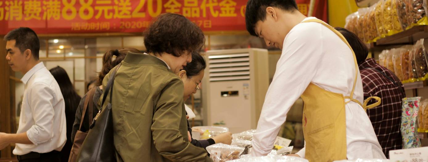 Shoppers comparing competitor flyers and coupons in a Giant Tiger aisle