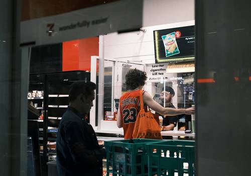 Canadian shopper scanning a grocery receipt with a coupon app at the supermarket checkout