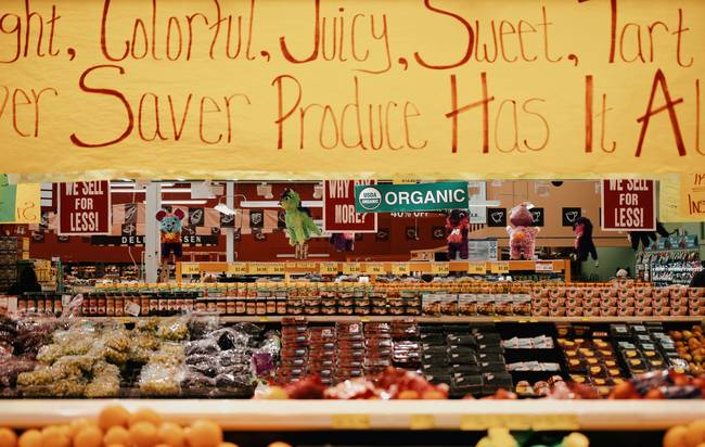 Canadian family using a grocery coupon app in a supermarket for digital savings
