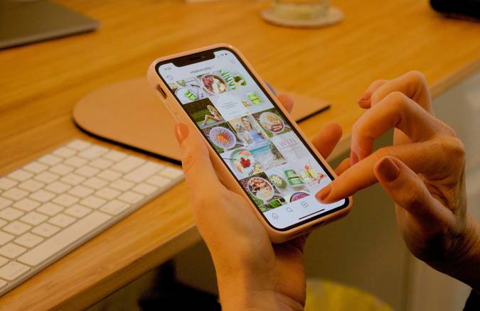 Canadian family using a grocery coupon app on a phone in a bright kitchen, planning grocery savings