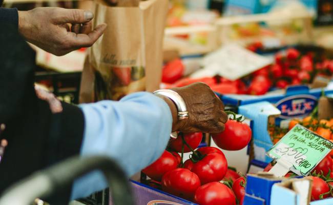 Canadian grocery shopper using coupons at the checkout for savings in a supermarket