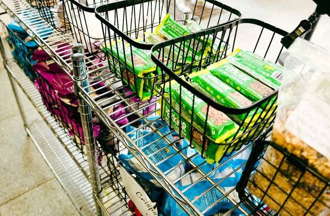 Canadian family using grocery coupons at a supermarket checkout for maximum savings