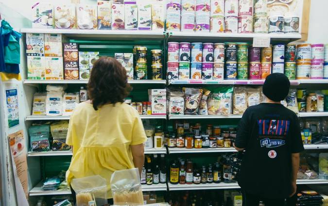 Canadian family using grocery coupons and mobile apps at a supermarket checkout