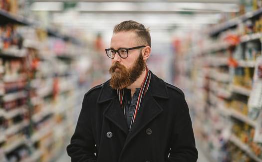 Person using a flyer comparison app to plan grocery shopping in Canada||woman on smartphone||grocery cart#|#Shopper checking flyer comparison tool on her phone in a grocery aisle#|#grocery-flyer-comparison-walkthrough.jpg