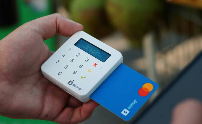 Canadian shopper scanning loyalty card at grocery checkout to earn points