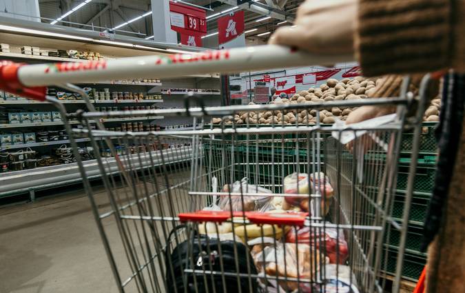 Canadian family using grocery coupons and loyalty points at supermarket checkout for big savings