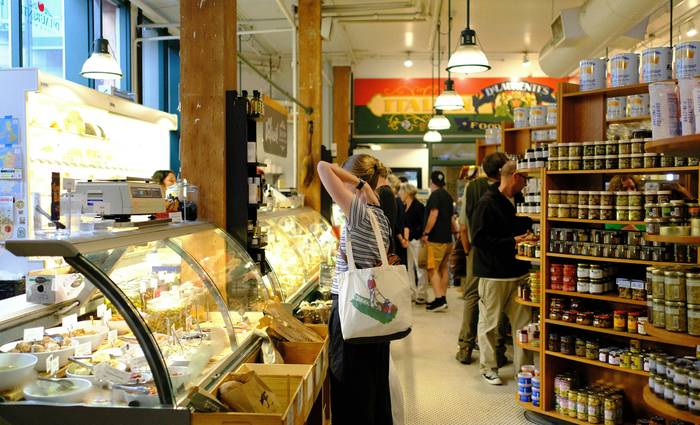 Canadian shoppers using in-store coupons at a grocery store checkout for exclusive savings