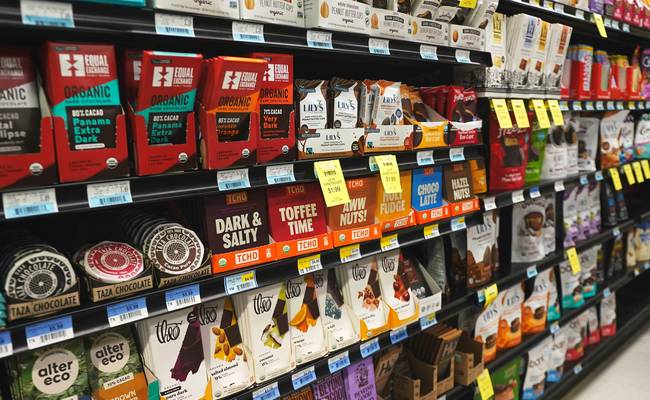 Canadian shopper using Loblaws coupons and PC Optimum app at grocery store checkout