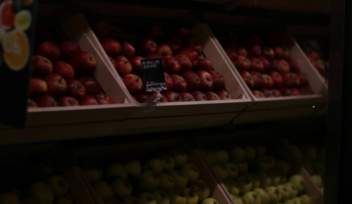 Canadian grocery shopper using Metro app to load digital coupons at supermarket checkout