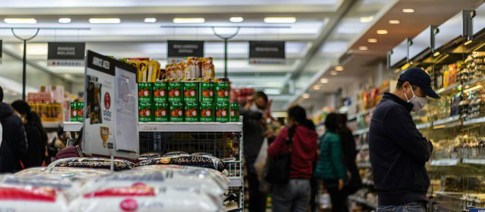 Shoppers using coupons in a Metro grocery store aisle in Canada