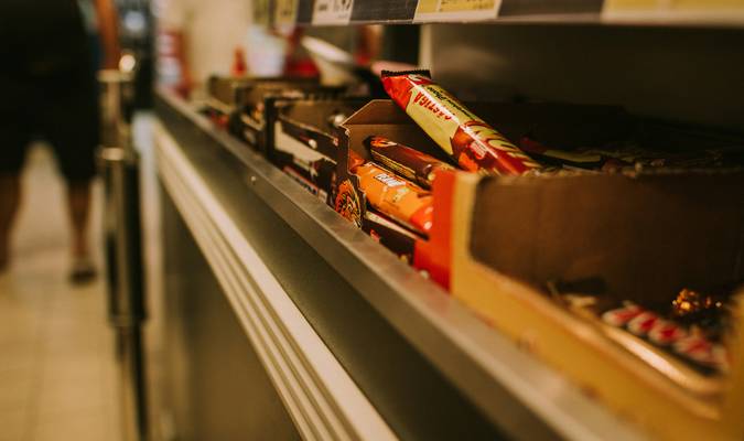 Grocery shopper using coupons and PC Optimum app at No Frills checkout counter