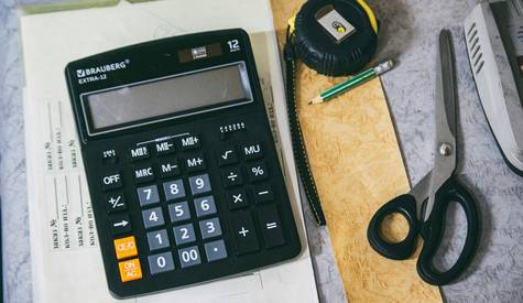 Canadian shopper using a calculator to estimate savings at No Frills grocery store