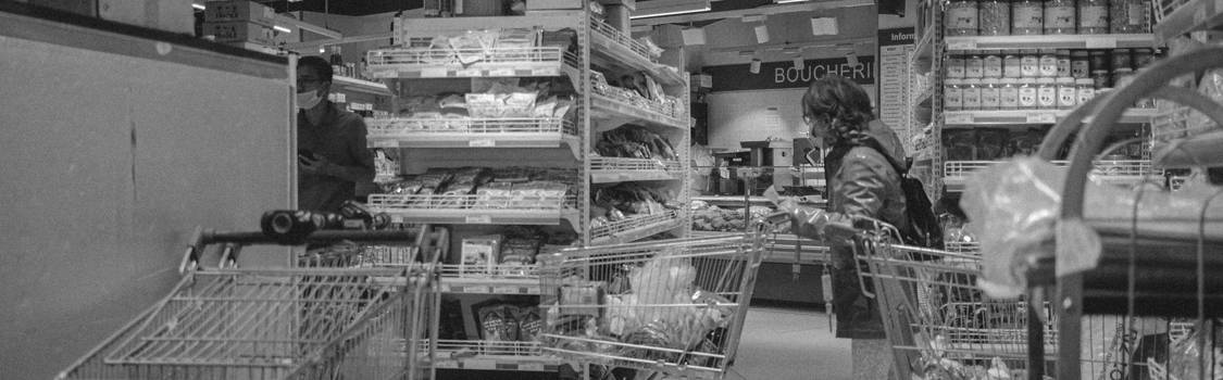 Shoppers with a cart in a No Frills grocery store aisle