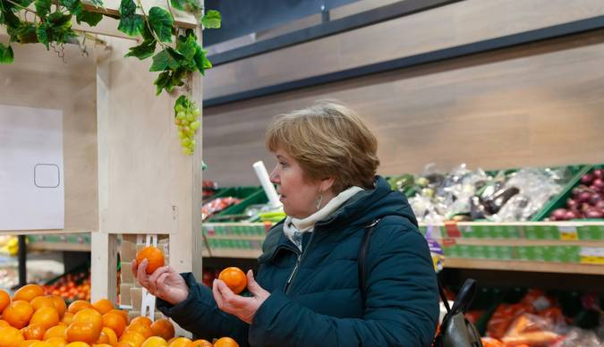 Shoppers browsing organic produce and using coupons at a Canadian supermarket