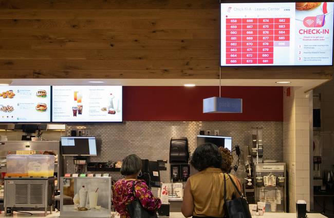 Canadian shopper using the PC Optimum app at a grocery store checkout for points and rewards