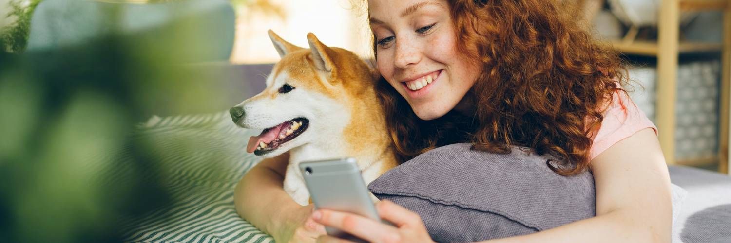 A smiling Canadian pet owner shops with PetSmart coupons in hand
