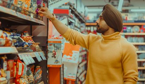 Canadian shopper using a phone to compare grocery prices and calculate savings