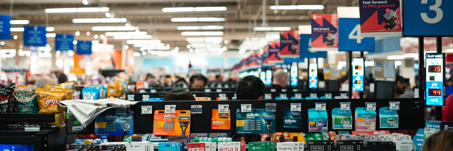 Canadian shoppers using printable coupons at a grocery store checkout