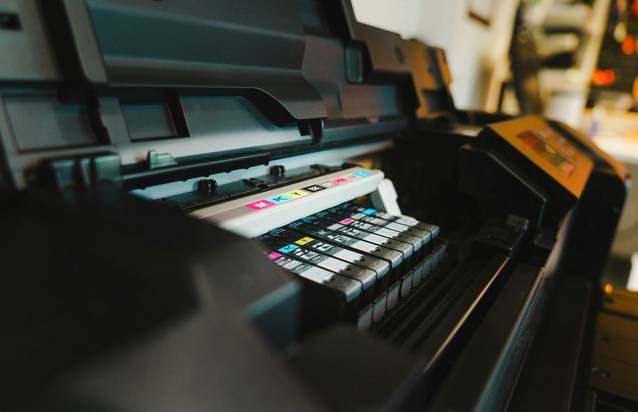 Canadian woman using a home printer to print grocery coupons for shopping savings