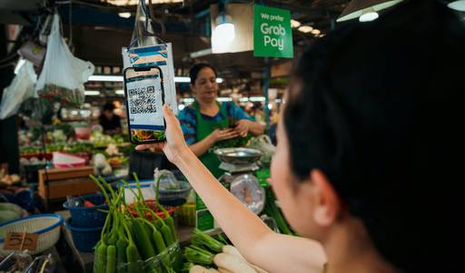Shopper handing a printable grocery coupon to a cashier at a Canadian supermarket