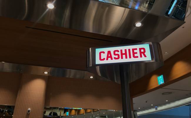 Cashier checks coupon at Canadian retail checkout counter