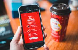 Canadian Scene+ loyalty app open on phone in a grocery aisle