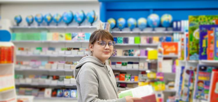 Customer holding Shoppers Drug Mart coupons in pharmacy aisle