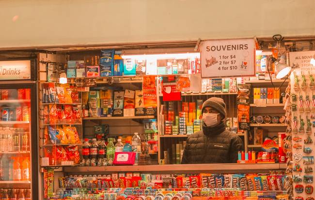 Canadian grocery shopper holding Sobeys coupons and phone in store aisle